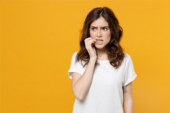 woman biting nails preventing dental implant care in Plano