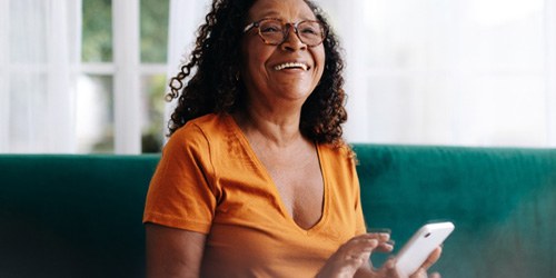 a woman smiling and holding her phone