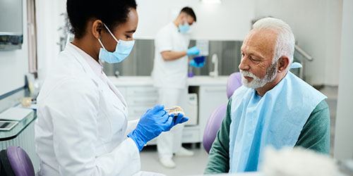 mature man at dentist with dentures in Plano 