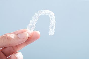Closeup of patient holding up clear aligners