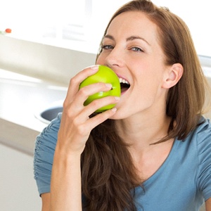 Woman enjoying an apple as part of a nutritious diet