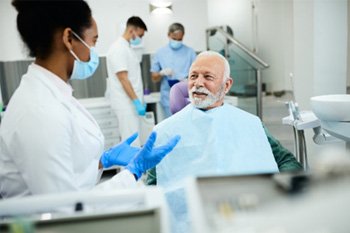 Cosmetic dentist talking to patient about causes of stained teeth