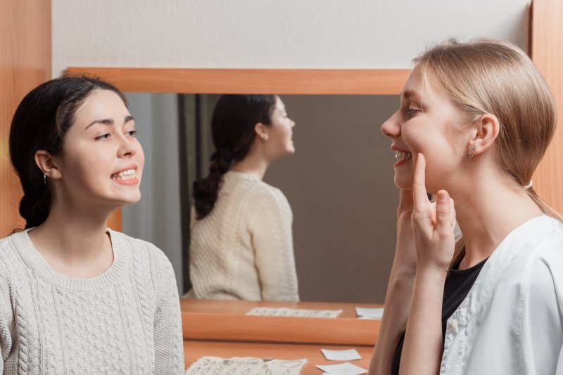 Two women practicing jaw exercises together