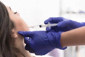 Botox being injected into woman’s jaw 