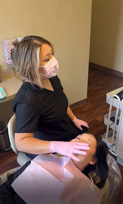 dental assistant placing invisalign aligners on a patient at Parkway Vista Dental in Plano, TX